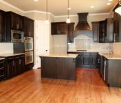 Stained Cabinetry w/ Subway Tile Backsplash and Tile Insert over Cooktop